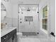 Sleek bathroom featuring a glass enclosed shower with custom tile and matte black hardware at 3417 Chilham Pl, Charlotte, NC 28226