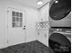 Stylish laundry room featuring dark tile floors and modern, stacked appliances at 3417 Chilham Pl, Charlotte, NC 28226