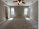 A spacious bedroom featuring a ceiling fan, two windows, and access to a closet and bathroom at 379 Maiden Sw Ln, Concord, NC 28025