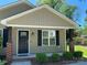 Inviting front porch with brick supports, a black front door with glass, and manicured landscaping at 379 Maiden Sw Ln, Concord, NC 28025