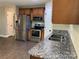 Modern kitchen features stainless steel appliances, granite countertops, and wooden cabinetry at 379 Maiden Sw Ln, Concord, NC 28025
