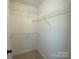 Walk-in closet featuring white walls, carpet flooring, and white shelving for ample storage at 379 Maiden Sw Ln, Concord, NC 28025