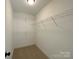 Walk-in closet featuring white walls, carpet flooring, and white shelving for ample storage at 379 Maiden Sw Ln, Concord, NC 28025