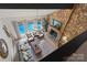 A living room with a stone fireplace and floor-to-ceiling windows overlooking the pool at 4039 5Th Nw St, Hickory, NC 28601