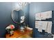 Elegant powder room featuring blue walls, a gold-framed mirror, and a unique vessel sink on a wooden vanity at 4039 5Th Nw St, Hickory, NC 28601