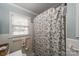 A bathroom with a shower curtain, tiled walls, a window, and a towel rack at 4544 Craig Ave, Charlotte, NC 28211