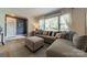 Living room with large sectional sofa, ottoman, and a view of the front yard through bright windows at 4544 Craig Ave, Charlotte, NC 28211