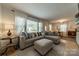 Cozy living room featuring a large sectional sofa, ottoman, and bright natural light from large windows at 4544 Craig Ave, Charlotte, NC 28211