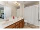 Bathroom with a double sink vanity, large mirror, and a shower-tub combination with a white shower curtain at 4861 Samuel Pinckney Dr, Belmont, NC 28012