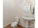 Well-lit powder room with pedestal sink, oval mirror, and wood-look flooring at 4861 Samuel Pinckney Dr, Belmont, NC 28012
