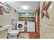 Functional laundry room with washer, dryer, toilet and unique overhead cabinets with a floral rug at 4935 Kennedy St, Hickory, NC 28602