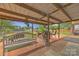 Covered patio featuring wooden beams, outdoor seating, and a landscaped yard with green grass at 4935 Kennedy St, Hickory, NC 28602