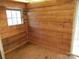 The shed has a sturdy wooden interior, a window that provides natural light and a rustic charm at 5180 Macedonia Church Rd, Vale, NC 28168