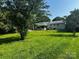 Expansive backyard featuring lush green grass, mature trees, and white brick house at 629 Belmorrow Dr, Charlotte, NC 28214