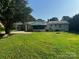 View of the home's back exterior with a screen porch, carport and large yard at 629 Belmorrow Dr, Charlotte, NC 28214
