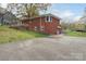 Backyard of a brick home featuring a deck, walk-out basement, and ample parking at 668 Riverside Dr, Lincolnton, NC 28092