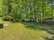 Spacious backyard with a lush lawn surrounded by mature trees and greenery at 7731 Ivy Hollow Dr, Charlotte, NC 28227