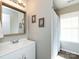 Bathroom vanity with white cabinets and a framed mirror next to a tub with a shower curtain at 7731 Ivy Hollow Dr, Charlotte, NC 28227
