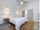 Bright bedroom featuring a ceiling fan, a comfortable bed and stylish sconces at 7731 Ivy Hollow Dr, Charlotte, NC 28227
