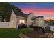 Beautiful backyard with patio, lounge seating, and charming string lights at twilight at 7850 Bud Henderson Rd, Huntersville, NC 28078