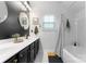 Nicely decorated bathroom features and round mirrors, dark cabinets, and a shower with a curtain at 7850 Bud Henderson Rd, Huntersville, NC 28078