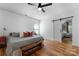Bright bedroom with wood floors, ceiling fan, barn door and window at 7850 Bud Henderson Rd, Huntersville, NC 28078