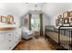 Cozy Bedroom with wood floors, crib, white dresser, white chair, and natural light at 7850 Bud Henderson Rd, Huntersville, NC 28078