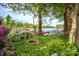 Lush backyard with a fire pit, abundant greenery, and beautiful lake views beyond at 7851 Green Cove Ct, Denver, NC 28037