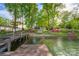 View of a wooden dock with lush surroundings, providing a serene and inviting spot by the water's edge at 7851 Green Cove Ct, Denver, NC 28037