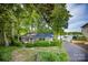Quaint brick home nestled among mature trees, featuring a lush front yard and a private driveway at 7851 Green Cove Ct, Denver, NC 28037
