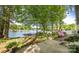Picturesque lake view featuring a dock, seating area, and landscaped yard with mature trees at 7851 Green Cove Ct, Denver, NC 28037