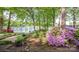 Beautiful lake view framed by lush trees and flowering shrubs, creating a serene setting at 7851 Green Cove Ct, Denver, NC 28037