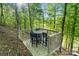 View of the wooden deck featuring an outdoor dining set nestled among lush trees at 8086 Summit Ridge Dr, Catawba, NC 28609