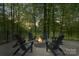 Outdoor seating area with inviting stone fire pit surrounded by mature trees and nature views at 8086 Summit Ridge Dr, Catawba, NC 28609