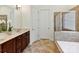 Primary bathroom showcasing double sinks, a glass shower, soaking tub and tile floor at 8708 Soaring Eagle Ln, Waxhaw, NC 28173