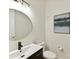 Contemporary bathroom with a black faucet, round mirror, and modern artwork at 8708 Soaring Eagle Ln, Waxhaw, NC 28173
