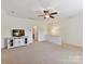 Spacious bonus room features neutral carpet, ceiling fan and media cabinet at 8708 Soaring Eagle Ln, Waxhaw, NC 28173