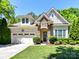 Charming home featuring a stone archway, manicured lawn, and a two-car garage at 8708 Soaring Eagle Ln, Waxhaw, NC 28173