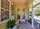 Inviting screened porch features a rocking chair and French doors to interior of the home at 8708 Soaring Eagle Ln, Waxhaw, NC 28173