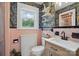 Eclectic bathroom with colorful jungle themed wallpaper, pink tile and modern wood vanity at 901 Central Dr, Kannapolis, NC 28083