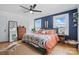 Bedroom featuring hardwood floors, two windows, blue accent wall, and a bed with a quilt at 901 Central Dr, Kannapolis, NC 28083
