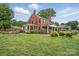 Sprawling red brick home with a manicured lawn and mature trees creating a peaceful setting at 901 Central Dr, Kannapolis, NC 28083