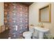 Eclectic half-bath with bold wallpaper, pedestal sink, and natural wood mirror frame at 901 Central Dr, Kannapolis, NC 28083