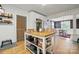 Kitchen island featuring wood countertop, metal shelving, and barstool seating in a bright, open kitchen at 901 Central Dr, Kannapolis, NC 28083