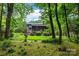 Backyard view of the house with a screen porch, landscaping, and trees at 9310 Hunting Ct, Matthews, NC 28105