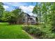 Exterior view of a beautiful backyard with a deck, screened-in porch, and mature trees at 9310 Hunting Ct, Matthews, NC 28105