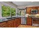 Functional kitchen featuring a stainless steel sink, modern appliances, and hardwood floors at 9310 Hunting Ct, Matthews, NC 28105
