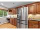 Modern kitchen with a stainless steel refrigerator, wooden cabinets, and hardwood floors at 9310 Hunting Ct, Matthews, NC 28105