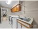 Well-equipped laundry room with cabinetry, shelving, sink, and modern washer and dryer units at 9310 Hunting Ct, Matthews, NC 28105
