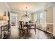 Formal dining room with a glass-top table, elegant chandelier, and natural light at 9517 Harris Glen Dr, Charlotte, NC 28269